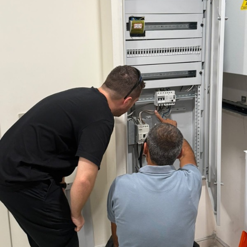 Bir elektrik panosunu birlikte inceleyen ekip